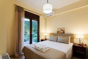 een slaapkamer met een bed met twee handdoeken erop bij Seaside Getaway - Aelia Villa's Dreamy Paradise in Petalidhion