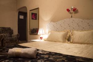 a bedroom with a large bed and a chair at Bishkek City Apartments in Bishkek