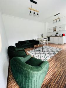 sala de estar con sofá verde y mesa en Apartament in regim hotelier King Medias, en Mediaş