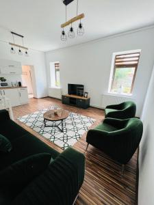 sala de estar con sillas verdes y mesa en Apartament in regim hotelier King Medias, en Mediaş