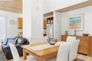 a kitchen and dining room with a wooden table and chairs at Cora Lynn 13 in Lorne