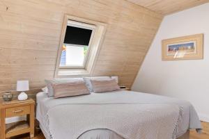 a bedroom with a bed with a wooden wall at Cora Lynn 13 in Lorne
