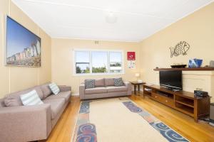 a living room with a couch and a flat screen tv at Anderson in Apollo Bay