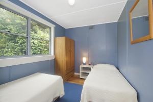 two beds in a blue room with a window at Anderson in Apollo Bay