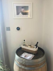 ein Weinfass mit einem Korb und einer Flasche Wein in der Unterkunft Unique one bedroom guest house with free parking in Aldershot