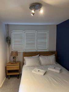 1 dormitorio con 1 cama blanca grande y pared azul en Unique one bedroom guest house with free parking, en Aldershot