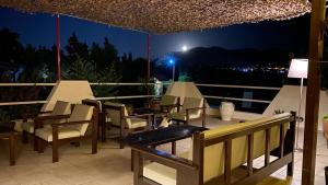 una terrazza con sedie e tavoli di notte di Arion Stables & Apartments a Hersonissos