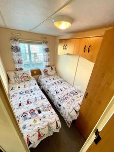 two twin beds in a small room with at Mablethorpe Seaside Holiday Home in Mablethorpe