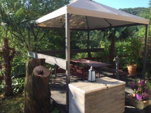 a picnic table under a white umbrella on a deck at Salara house in Koper