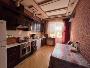 a kitchen with black cabinets and a brick wall at Riva Seaside House in Lankaran