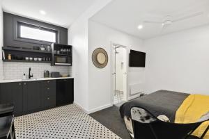a bedroom with a bed and a kitchen with a sink at Joy Apartment 5 in Lorne