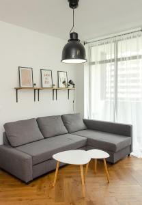 sala de estar con sofá gris y mesa blanca en The Residential 1-BD Apartment with an Outdoor Thermal Pool en Varna