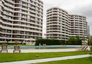 two large apartment buildings with a pool in front of them at The Residential 1-BD Apartment with an Outdoor Thermal Pool in Varna City