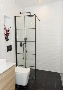 a bathroom with a toilet and a glass shower at The Residential 1-BD Apartment with an Outdoor Thermal Pool in Varna City