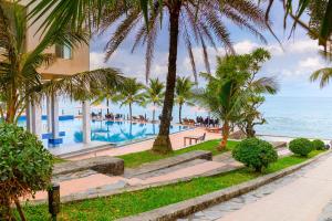 un complexe avec une piscine et l'océan dans l'établissement Sun Viet Resort Phu Quoc, à Duong Dong
