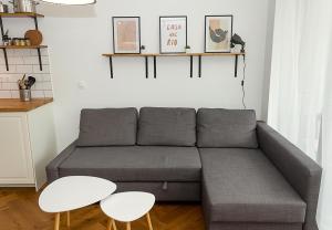 The Residential 1-BD Apartment with an Outdoor Thermal Pool في مدينة فارنا: غرفة معيشة مع أريكة رمادية وطاولتين بيضاء