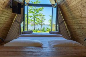 Bett in einem Zimmer mit einem großen Fenster in der Unterkunft Perryland Urban Farm in Piatra