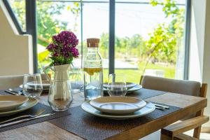 a table with plates and glasses and a vase of flowers at Perryland Urban Farm in Piatra