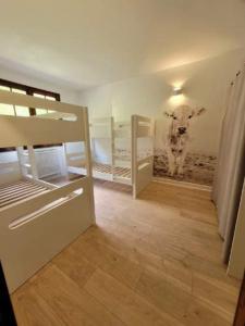 a room with two bunk beds and a cow in the wall at Maison 15 personnes aux pieds des Pyrénées in Sarrancolin