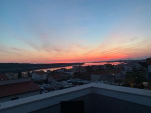 una vista de la puesta de sol desde el techo de un edificio en Apartments Casa Barbara, en Rab