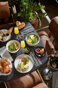 Ink Hotel في تل أبيب: طاولة عليها أطباق من المواد الغذائية والمشروبات