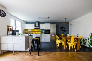 a kitchen and dining room with yellow chairs and a table at KAwaii- Big island in central location in Karlsruhe