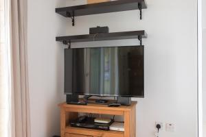 a flat screen tv on top of a wooden stand at Sea view apartment in St Paul's Bay in St. Paul's Bay