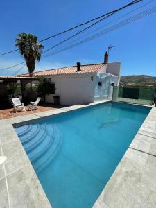 a swimming pool in front of a house at Casa Rural Los Caballos Finca Canca Alora Caminito del Rey in Alora