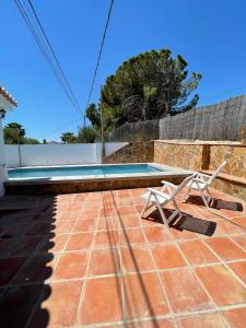 un patio con banco y piscina en Casa Rural Los Caballos Finca Canca Alora Caminito del Rey en Alora