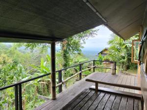 un porche de madera con un banco encima en Sang Giri - Mountain Glamping Camp, en Jatiluwih