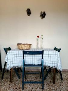 une table avec un chiffon de table bleu et blanc et deux chaises dans l'établissement Anogeio - Traditional house in Tikhion, à Tíkhion