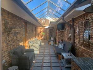 a patio with couches and a glass roof at Dobbs Lodge in Centurion