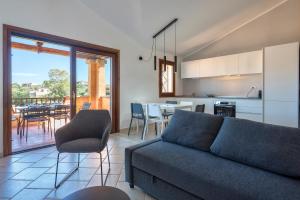a living room with a couch and a kitchen with a table at House of Lens in Golfo Aranci