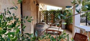 a porch with a chair and a table and a fence at Antica Masseria Ficazzana - Tenuta in Marina di Pescoluse