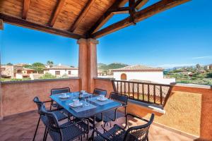 eine Terrasse mit Tisch und Stühlen auf einem Balkon in der Unterkunft House of Lens in Golfo Aranci