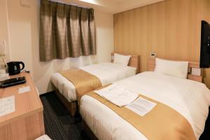 a hotel room with two beds and a television at Hotel -ASIATO- in Osaka +10 photos
