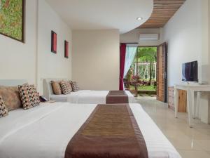 Habitación de hotel con 2 camas y TV en The Village Resort Bogor By Waringin Hospitality, en Bogor