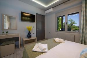 ein Schlafzimmer mit einem Bett mit zwei weißen Handtüchern darauf in der Unterkunft Rena's luxury apartment with free private parking in Chania