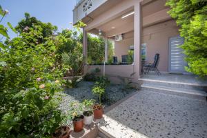 a backyard with plants and a house at Rena's luxury apartment with free private parking in Chania