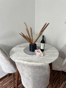 een tafel met een fles wijn en twee stoelen bij Apartament in regim hotelier Queen Medias in Mediaş