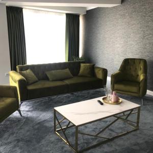 Sala de estar con sofá, 2 sillas y mesa de centro en Hotel SunGarden Salin, en Turda