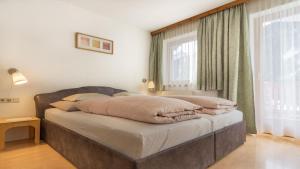 Haus Ferchl في نيوستيفت ام ستوبايتال: سرير في غرفة ذات نافذة كبيرة