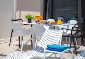 - une table et des chaises avec une assiette de fruits dans l'établissement LUMIERE VILLAS, à Kanali