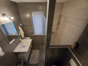 a bathroom with a shower and a sink and a mirror at Apartments LAURA in Fažana