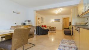 Haus Ferchl في نيوستيفت ام ستوبايتال: مطبخ وغرفة معيشة مع طاولة وكراسي