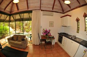 a kitchen and living room with a table and chairs at Waterfall Cottages in Margaret River Town