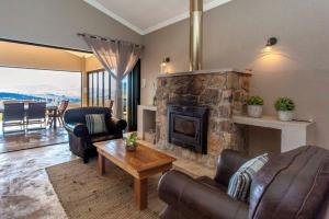 a living room with a stone fireplace and furniture at Ilanga Game & Fishing Lodge in Dullstroom