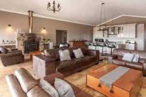 a living room with leather furniture and a fireplace at Ilanga Game & Fishing Lodge in Dullstroom