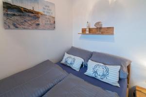 ドルヌマージールにあるLüttje Nestのベッドルーム1室(青と白の枕が備わるベッド1台付)