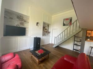 un soggiorno con divano rosso e TV di Château de Courbouzon & SPA a Courbouzon